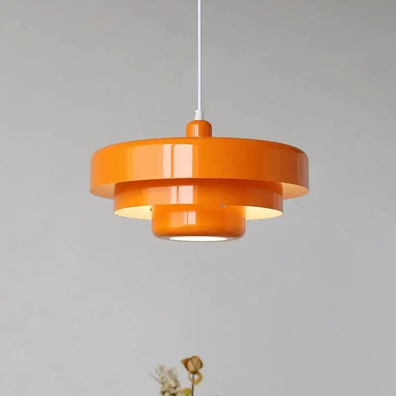 Vibrant orange tiered pendant lighting with glossy finish and concentric circular design in Bauhaus retro pendant style