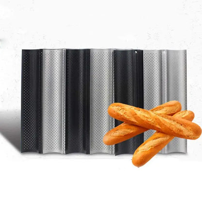 Set of black and silver perforated metal wave bread pans with non-stick surface displayed with golden-brown baguettes