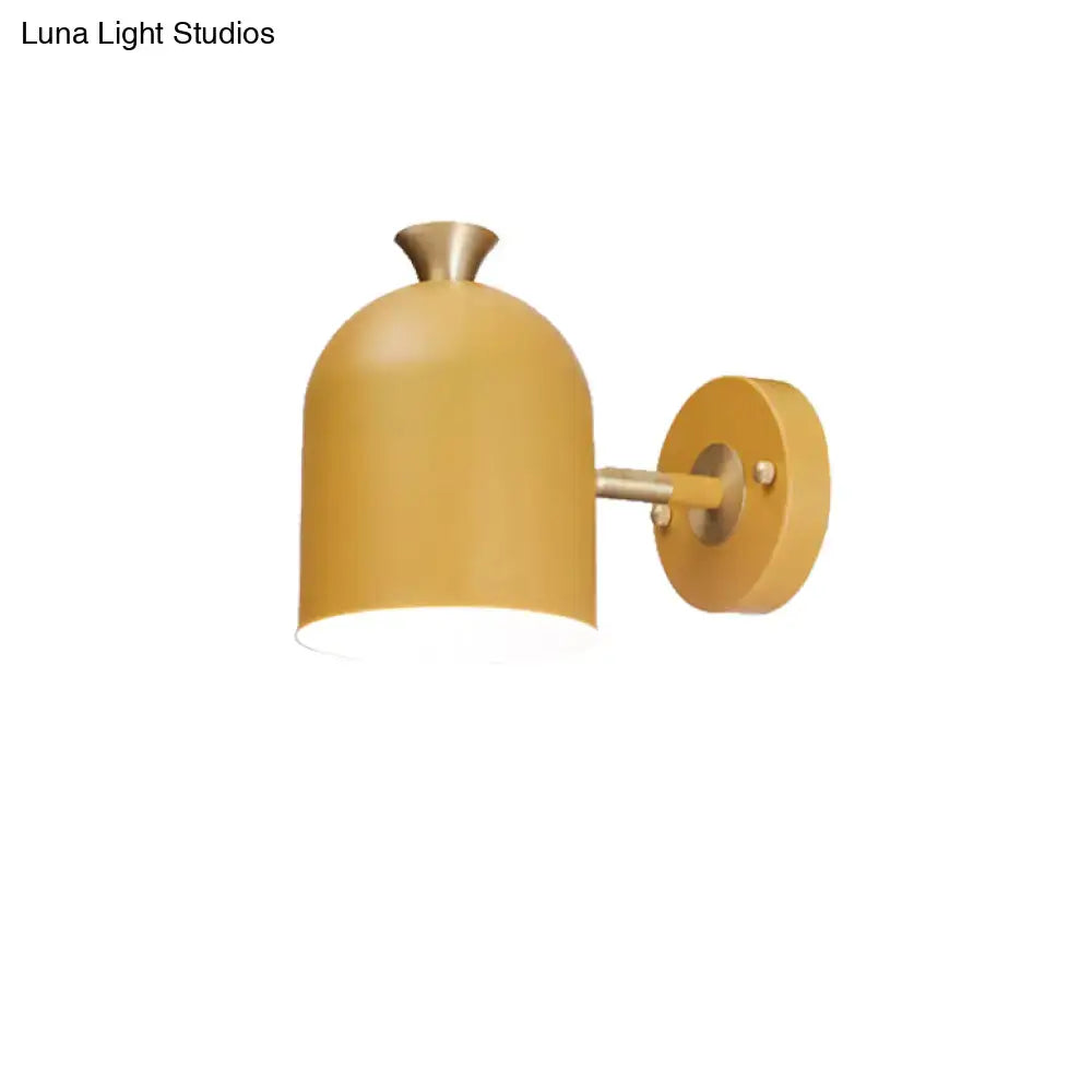 A sleek mustard-yellow wall light sconce lamp with matte dome cup shade and brass accents for dining room use