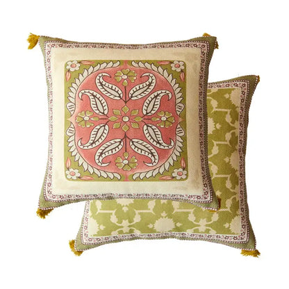 Square cushion with vibrant pink and green datura flowers print, cream border, and mustard-yellow tassels for living room decor