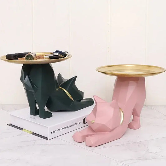 Pink and green geometric cat storage figurines with gold-trimmed circular tops for entrance hallway trays