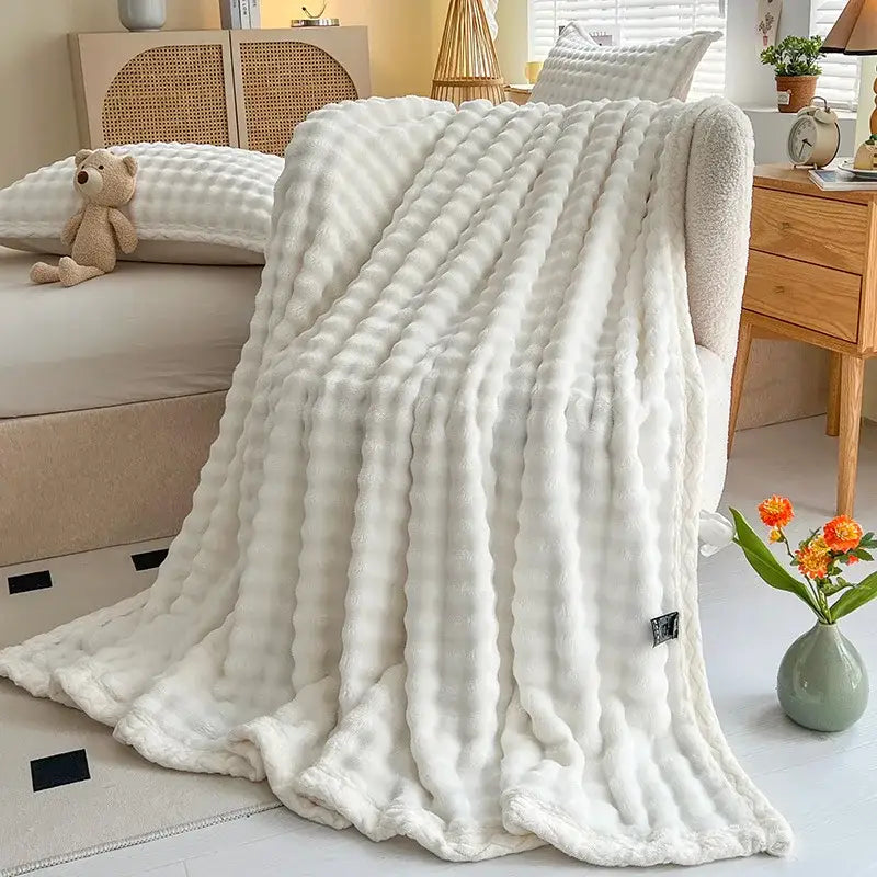 A plush white ribbed textured throw blanket made of decorbites cozy faux rabbit fur for bedroom use