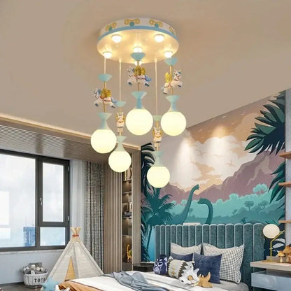 Whimsical pink and white unicorn led pendant ceiling light with blue and white patterned base and hanging carousel horse bulbs