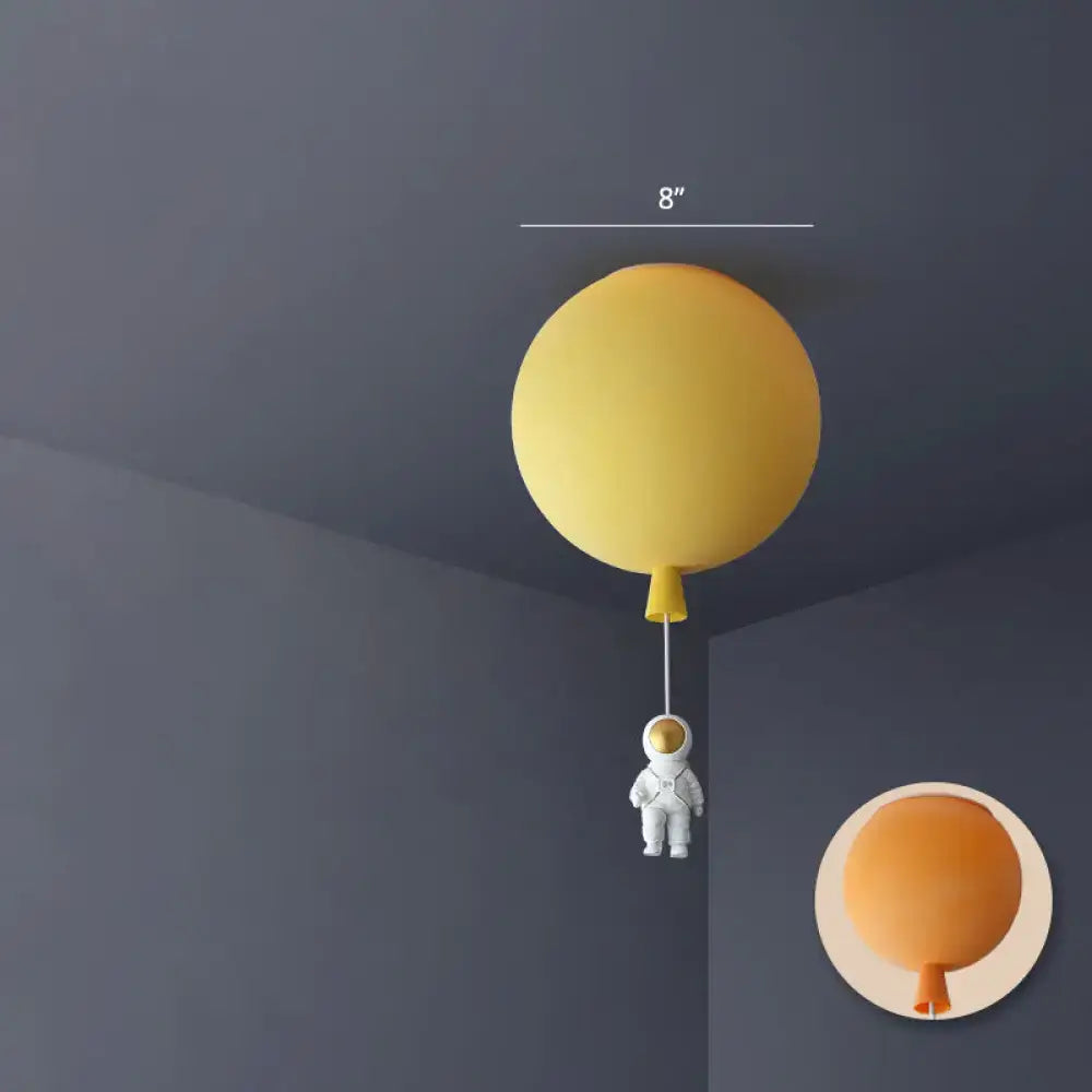 Yellow balloon-shaped acrylic pendant light with a miniature astronaut figure hanging below, pink astronaut ceiling lamp for kids bedroom