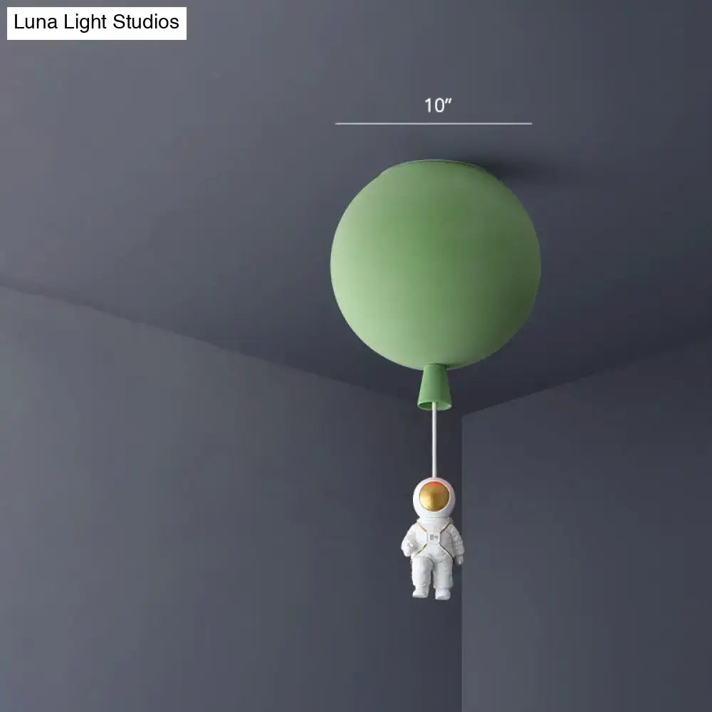 Whimsical green balloon-shaped acrylic pendant light with a white astronaut figurine kid’s bedroom ceiling lamp