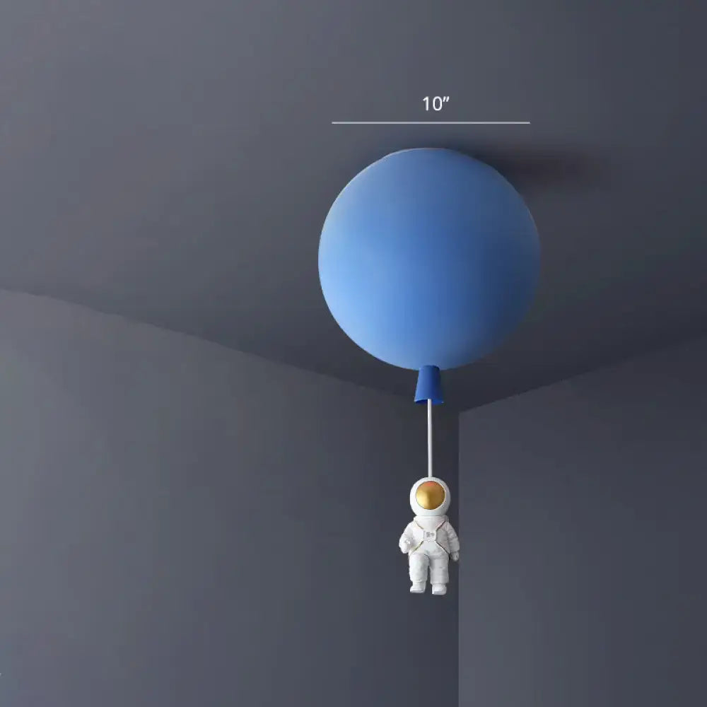 Blue balloon-shaped acrylic pendant light with white astronaut figurine hanging below in a kids bedroom ceiling lamp