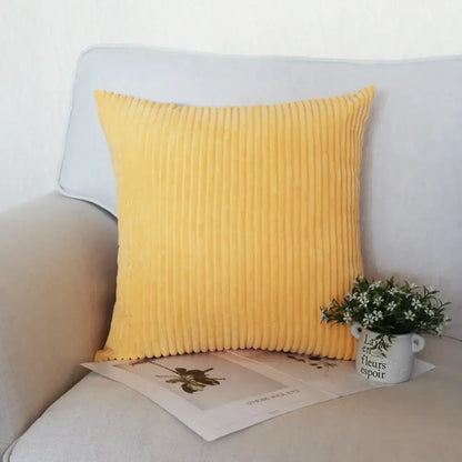 A vibrant yellow decorbites corduroy pillow with soft ribbed texture on light gray sofa for living room decor