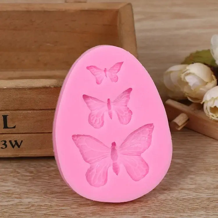 Pink butterfly silicone fondant mold featuring three egg-shaped butterfly designs for decorbites cake decorating use