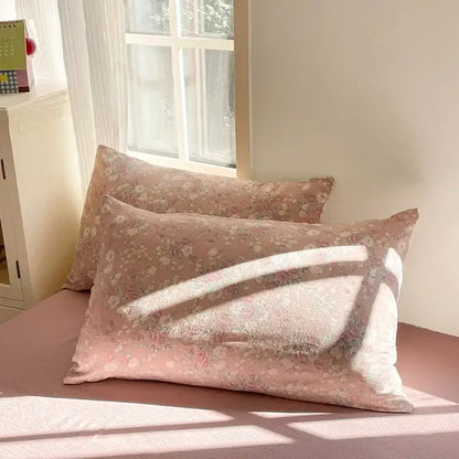 Soft pink floral pillowcases with delicate blossoms and subtle texture on a matching double layer yarn bedspread set
