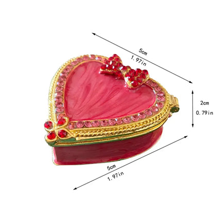 Pink floral heart jewelry trinket box with vibrant pink enamel, gold-toned rhinestone border, and red jeweled bow storage case