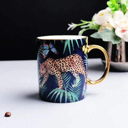 A navy blue ceramic mug with gold rim and handle featuring an illustrated leopard and tropical jungle animals decorbites bone china design