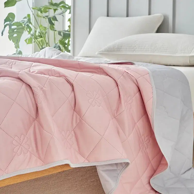 Pink quilted cool summer blanket with subtle floral embroidery and white border for bedroom cooling comforter