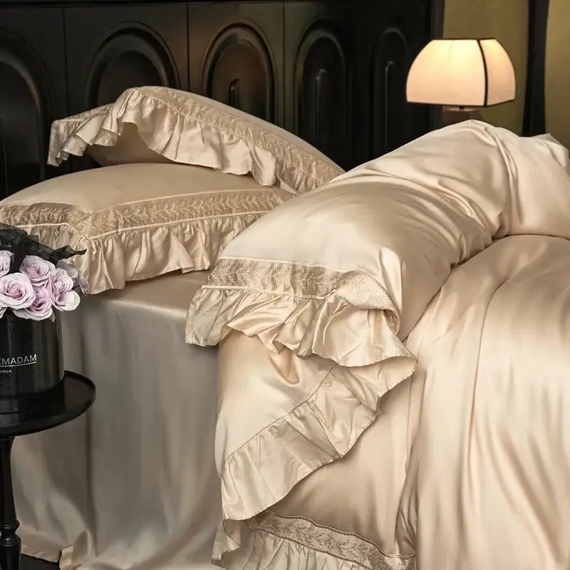Cream-colored satin pillowcases with delicate lace trim and layered ruffles from decorbites 1000tc luxury embroidery bedding set