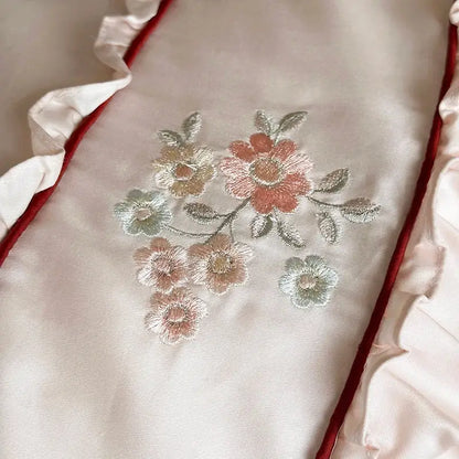 A cream satin pillowcase with intricate floral embroidery and red lace ruffles from decorbites 1000tc cotton bedding set