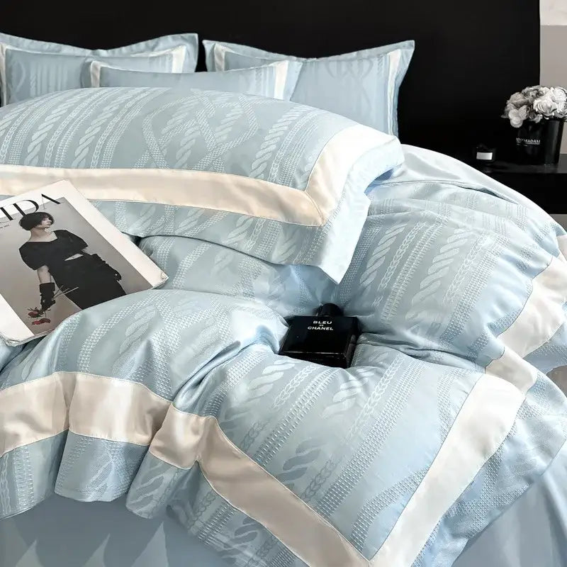 Light blue satin duvet cover set with cream piping and subtle woven leaf pattern for elegant bedroom use