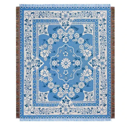 Blue floral knitted blanket with cream accents and fringed edges used as a cat strawberry knitted decorbites throw