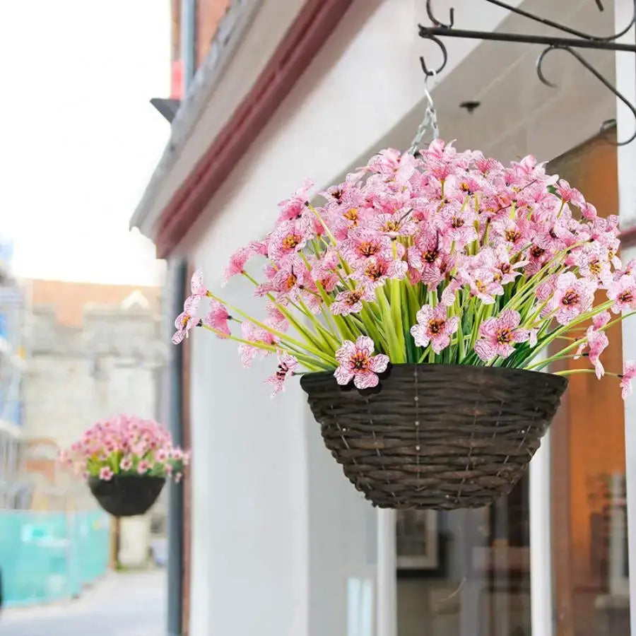A hanging wicker basket filled with artificial pink and white cherry blossoms and green stems for wedding decor