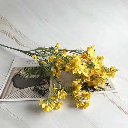 A vibrant yellow artificial flower arrangement with delicate petals and green stems from decorbites imitation flower collection