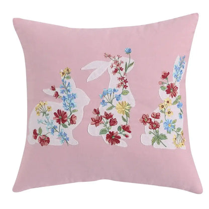 Pink cushion cover featuring three embroidered white bunnies with colorful floral patterns decorbites bunny cushion