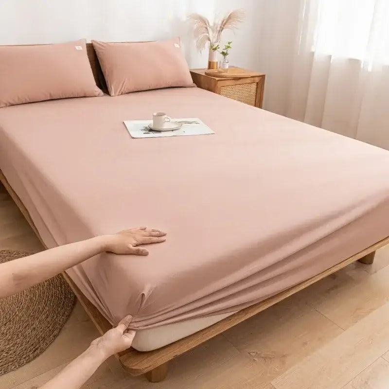 Soft blush pink decorbites cotton fitted sheet with smooth stretchy fabric draping elegantly over mattress