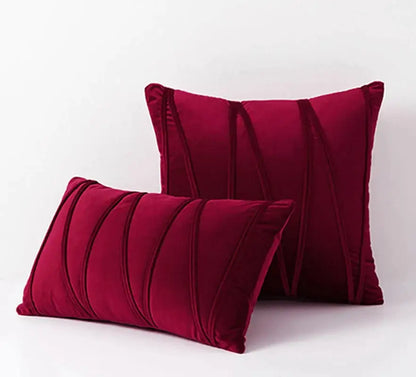 Deep red velvet pillows with vertical pleated detailing complement knit short wool velvet decor for living room use