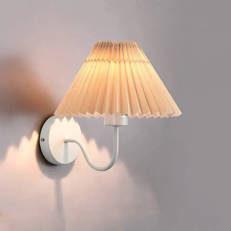 A warm-toned white decorbites cloth lampshade wall lamp with a pleated design and led light for bedroom and living room