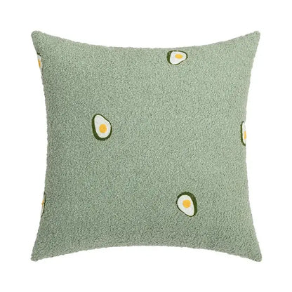 A plush moss-green faux fur cushion cover with embroidered avocado halves paired with decorbites houndstooth cushion cover