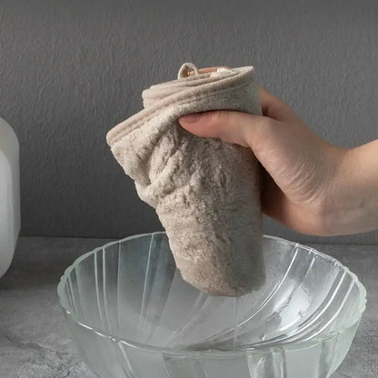Beige plush coral velvet soft hand towel with bow held above glass bowl for kitchen and bathroom use decorbites coral velvet