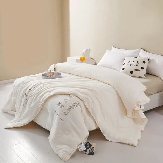 Plush cream cozy soy fiber quilt with subtle black text and soft texture ideal for bedroom bedding decorbites cozy soy