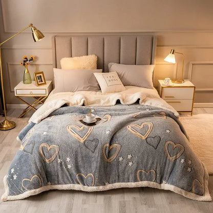 A cozy gray fleece wool blanket with embroidered gold and black hearts and stars and soft white sherpa trim