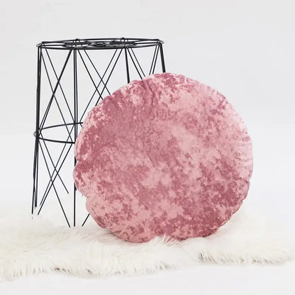 A plush round pink velvet pillow cover with a soft textured surface for living room decor dark grain style