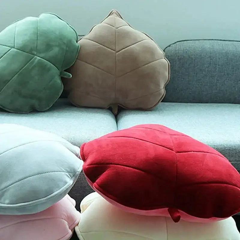 Soft plush leaf shaped throw pillows in sage mustard green beige and pastel shades on a gray couch for living room decorbites 3d leaf