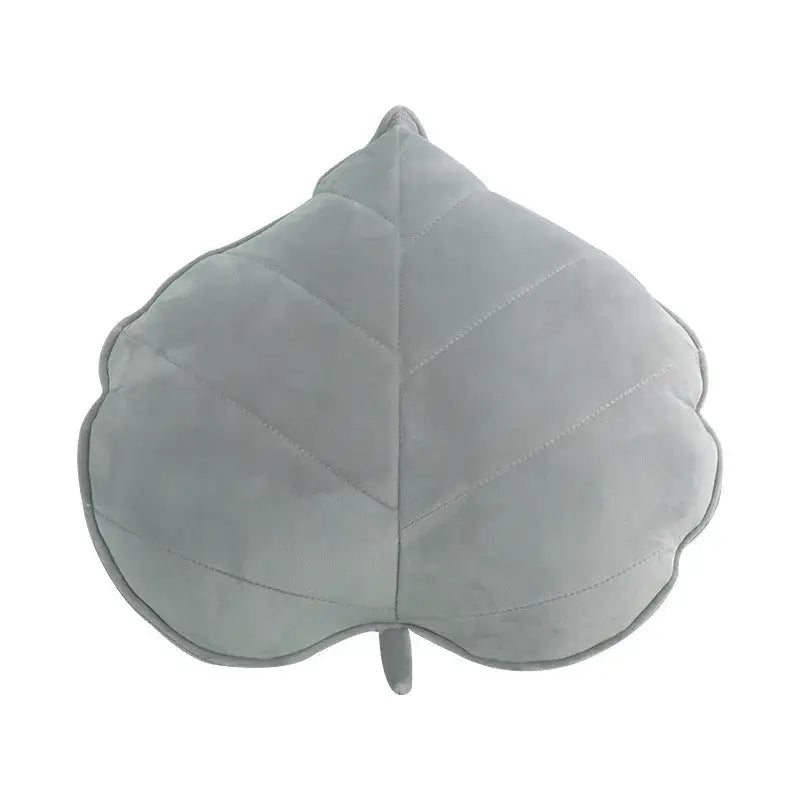 A soft light gray plush leaf shaped throw pillow with stitched veins and stem from decorbites 3d leaf collection for living room decor