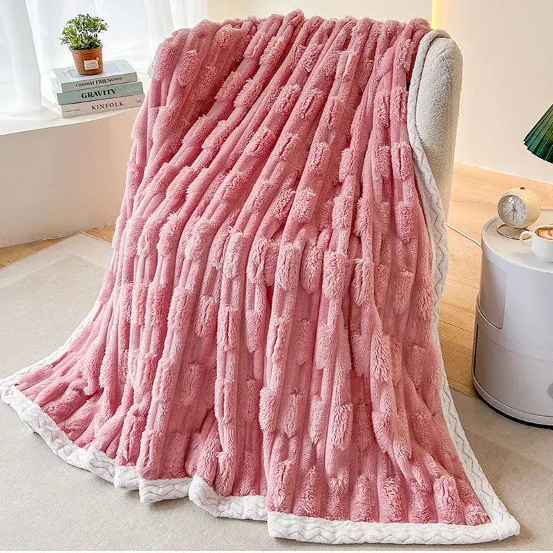 Plush pink bamboo velvet blanket with textured fuzzy surface and white braided trim for bedroom throw use