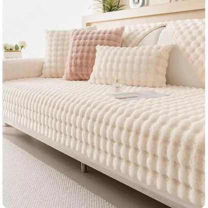 Cream-colored plush sofa slipcover with raised quilted pattern in beige and cream rabbit fur for living room use