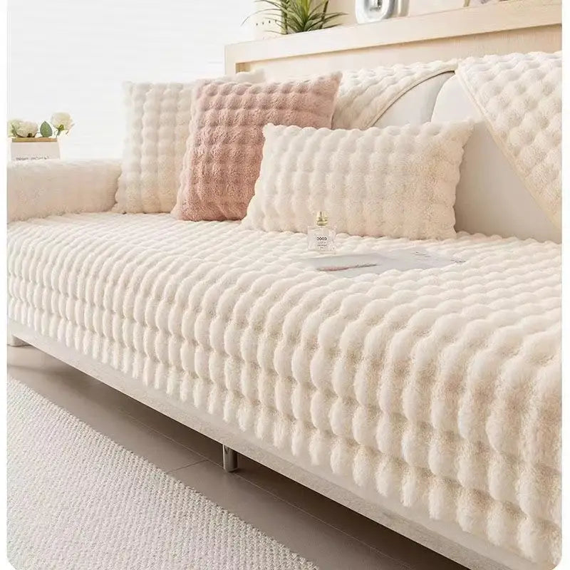 Cream-colored plush sofa slipcover with raised quilted pattern in beige and cream rabbit fur for living room use