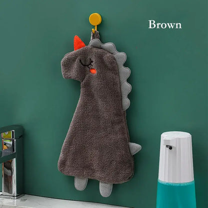 Brown plush dinosaur-shaped hand towel with orange horn and gray spines made of double-layer coral velvet material