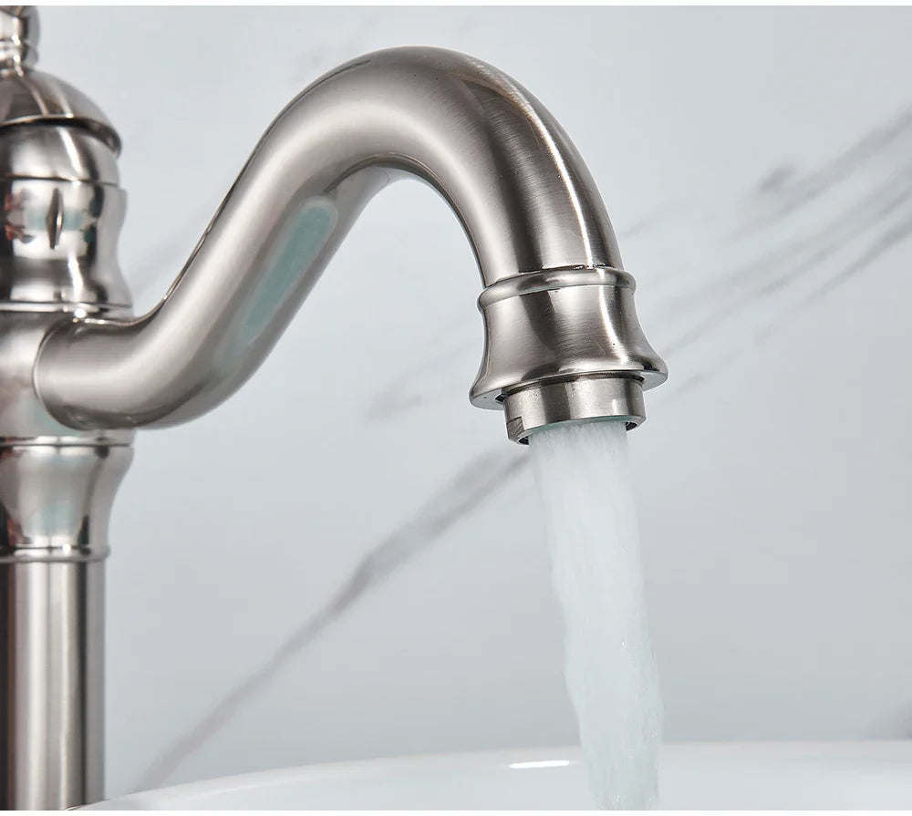 A sleek brushed stainless steel deck mounted single hole kitchen faucet with curved spout and polished finish housing material