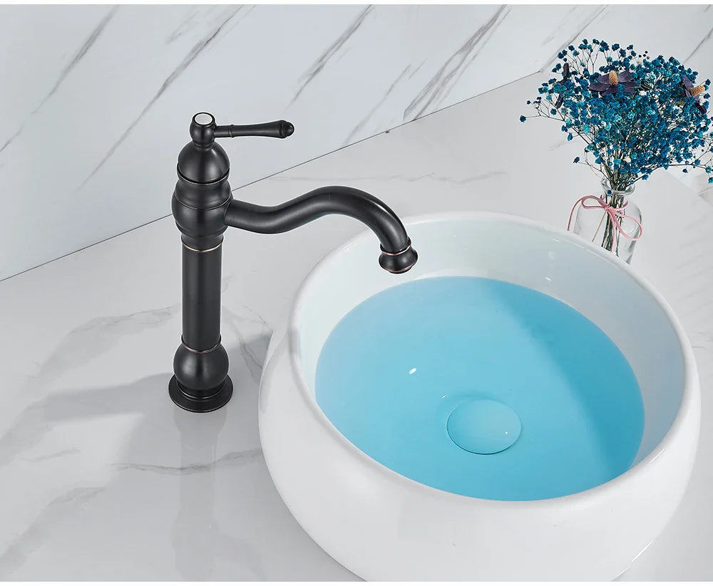 Black matte single hole deck mounted faucet with curved spout and ornate detailing for basin vessel sink