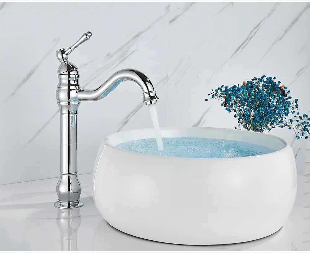 Chrome finished single hole deck mounted bathroom faucet with curved spout and decorative knob beside white ceramic sink