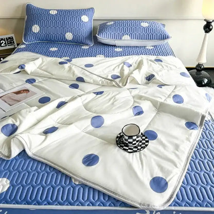 White quilt with blue polka dots and stitched padded design as part of a polka dot smile cool comforter set