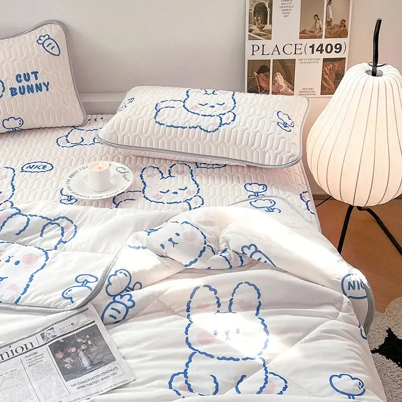 White quilted cool comforter set with blue-outline bunny designs and pink accents in polka dot smile style