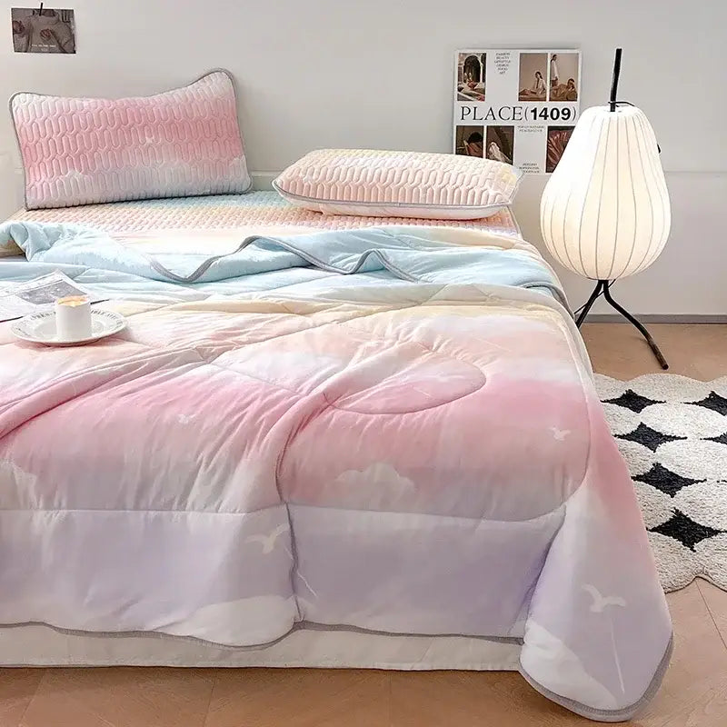 Pastel gradient quilted comforter with soft pink lavender and light blue hues featuring white bird motifs in cool comforter set