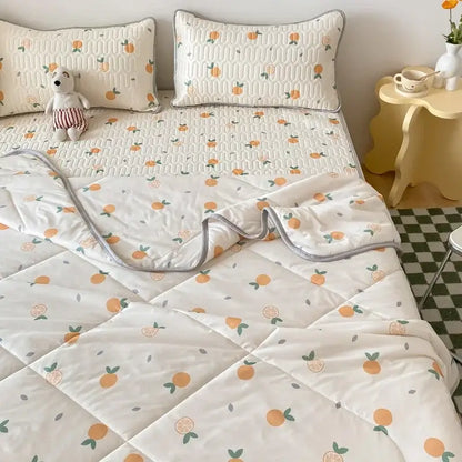 White quilted cool comforter set with playful orange and green citrus pattern and soft gray piping edges