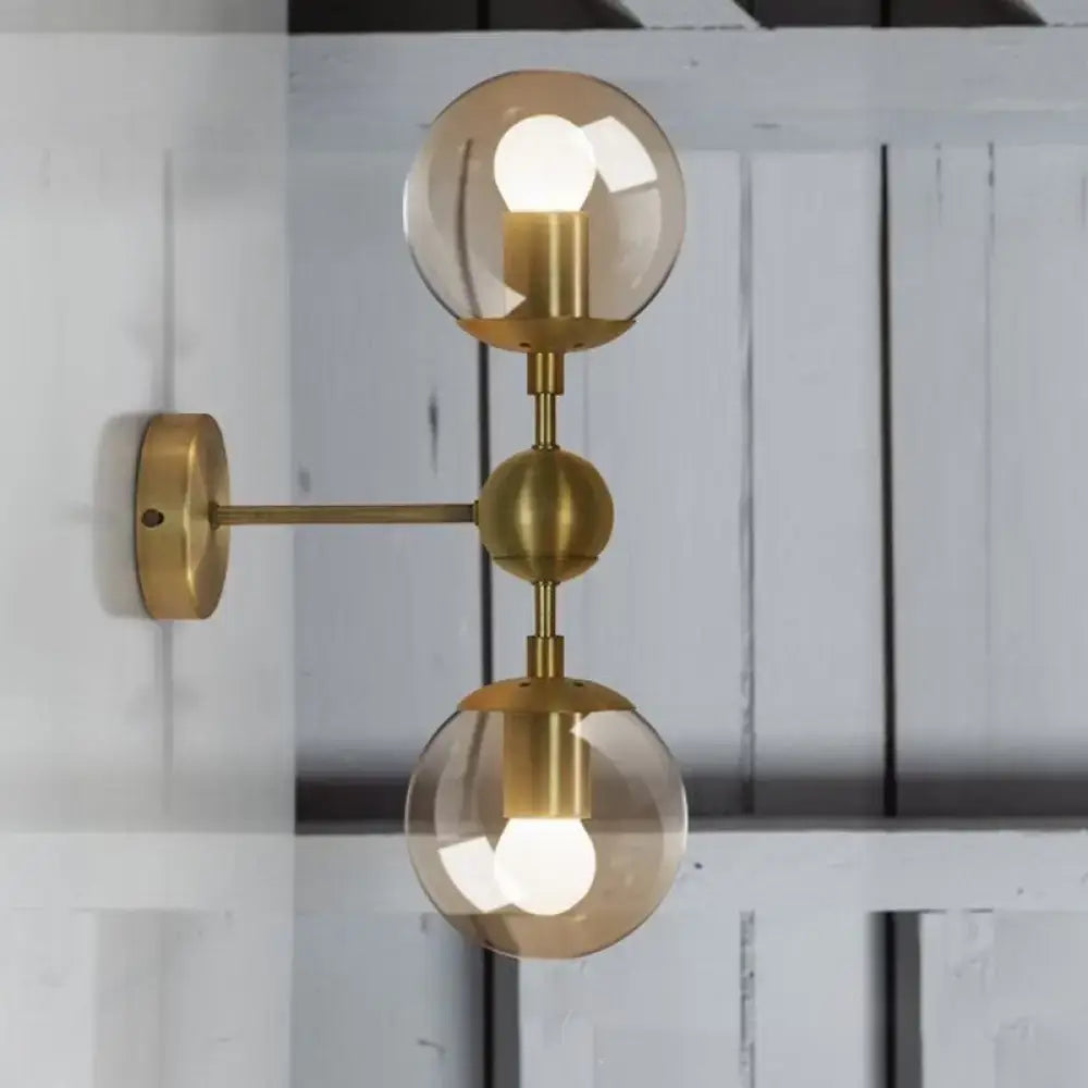 Post modern brass wall light with two spherical amber glass shades compatible with e26 e27 bulbs for bedroom use