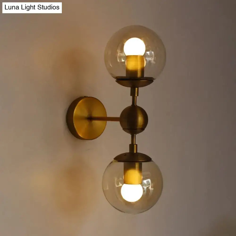 Post modern brass wall light with amber glass spherical globes featuring warm e26 e27 bulbs for bedroom use