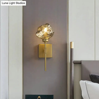Post modern brass and amber glass wall light sconce with gold-toned textured irregular glass shade for living room