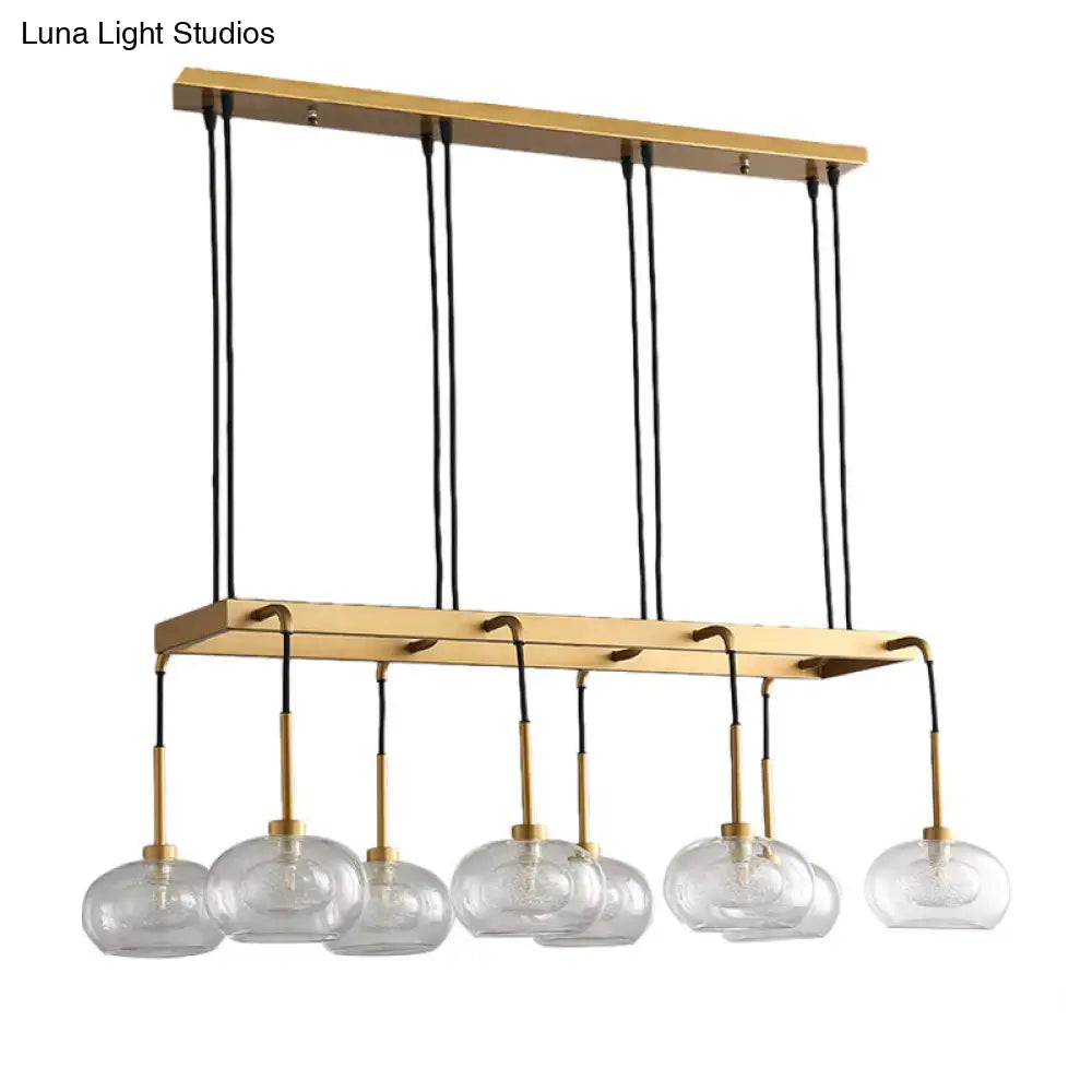 Gold-toned decorbites post-modern rectangular chandelier with six clear glass globe shades and brass accents suspended by black cords