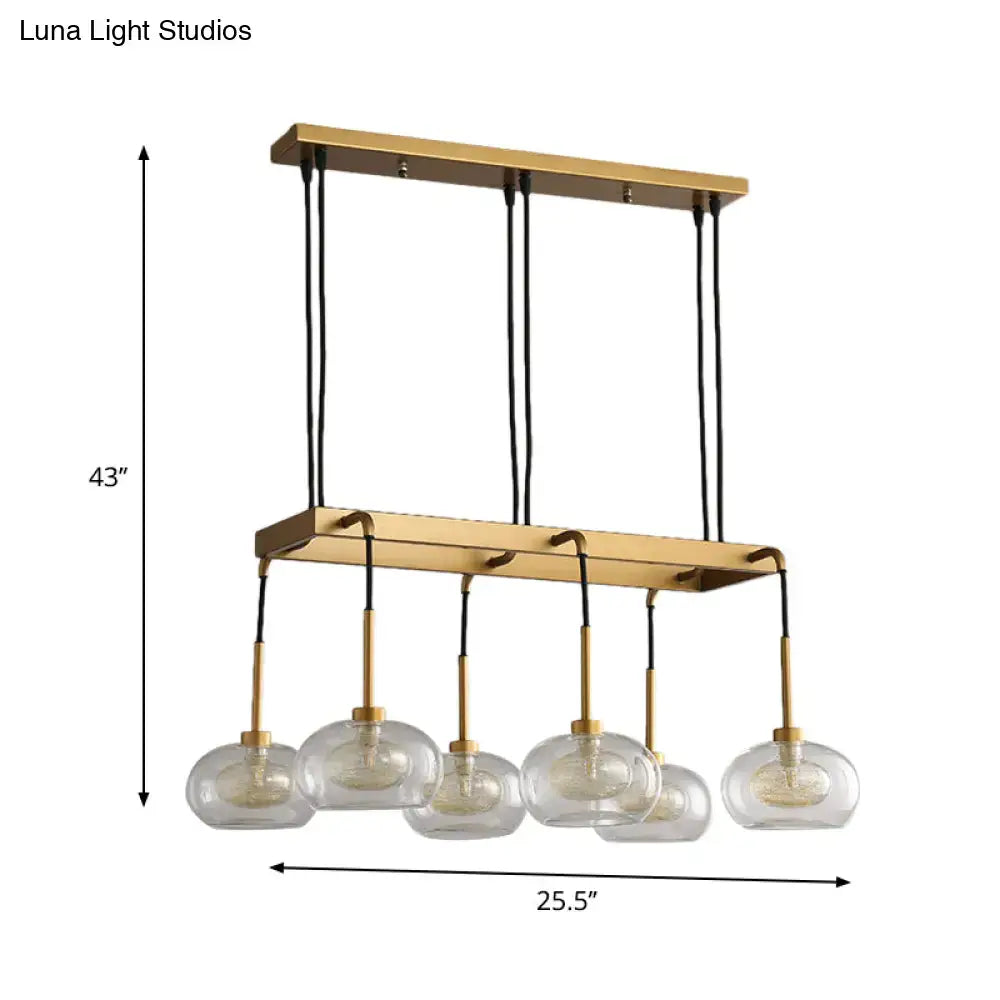 Gold-toned rectangular DecorBites island chandelier with five clear glass globe shades suspended by black cords