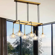 DecorBites post-modern island chandelier with gold finish and five clear glass globe shades suspended by black cords